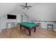 A full view of the open game room featuring a pool table, high ceilings, and a mounted television at 110 Black Swan Dr, Youngsville, NC 27596