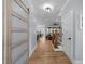 Hallway with wood floors, wood-trimmed doorways, and a view to an open floor plan at 110 Black Swan Dr, Youngsville, NC 27596