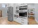 Kitchen area features stainless appliances, white cabinets, wine rack, wood floors, and stairs to the second level at 110 Black Swan Dr, Youngsville, NC 27596