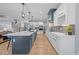 Spacious kitchen features a large island with sink, white cabinets, stainless appliances, and wood flooring at 110 Black Swan Dr, Youngsville, NC 27596