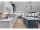 Open kitchen with large island, white and blue cabinets, stainless appliances, and view to the dining room at 110 Black Swan Dr, Youngsville, NC 27596