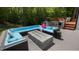 Inviting patio with blue cushioned seating, outdoor kitchen area, a grill and a modern fire pit at 110 Black Swan Dr, Youngsville, NC 27596
