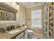 Bright bathroom featuring granite countertop, white cabinets, decorative shower curtain, and a window for natural light at 1104 Garnet Ridge Way, Raleigh, NC 27607
