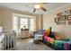 Bright bedroom with a bay window, crib, play tent, and neutral decor creating a cozy, playful atmosphere at 1104 Garnet Ridge Way, Raleigh, NC 27607