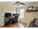 Home office with hardwood floors, dual monitor computer setup, and comfortable leather sofa at 1104 Garnet Ridge Way, Raleigh, NC 27607