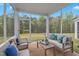 Inviting screened porch featuring comfortable seating and scenic views of the backyard landscape at 1131 Pate Farm Ln, Durham, NC 27703