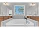 Luxurious soaking tub with stylish faucet and beautiful views from the window, perfect for relaxation at 1160 Craigmeade Dr, Morrisville, NC 27560