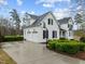 Exterior view of the white home with attached garage, featuring well-maintained landscaping and a basketball hoop at 1188 The Preserve Trl, Chapel Hill, NC 27517