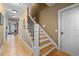Spacious hallway with hardwood floors, staircase with black metal railing, and multiple doors at 1188 The Preserve Trl, Chapel Hill, NC 27517