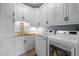 Bright laundry room featuring white cabinets, granite countertops, and modern appliances at 1188 The Preserve Trl, Chapel Hill, NC 27517