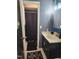 Compact bathroom with a dark vanity, gold hardware, and tiled floors at 1209 Mill Valley Rd, Fuquay Varina, NC 27526