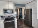 Modern kitchen features white cabinets, stainless steel appliances, and a view to the entryway at 1209 Mill Valley Rd, Fuquay Varina, NC 27526