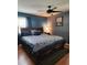 Cozy main bedroom with plush bedding, wood floors, and a ceiling fan at 1209 Mill Valley Rd, Fuquay Varina, NC 27526