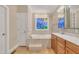 Bathroom with double sink vanity, soaking tub with decorative window, and tile floors at 1220 Bethlehem Rd, Knightdale, NC 27545