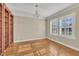 Bright, empty room with hardwood floors, a chandelier, and plantation shutters; bookshelves on the left at 1220 Bethlehem Rd, Knightdale, NC 27545