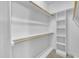 Bright walk-in closet features white shelving and wooden clothes rods at 1220 Bethlehem Rd, Knightdale, NC 27545