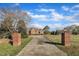 Long driveway leading to a charming brick home, framed by brick pillars and lush greenery at 1220 Bethlehem Rd, Knightdale, NC 27545