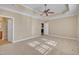 Carpeted main bedroom featuring a tray ceiling, ceiling fan and doorways to the bath and kitchen at 1220 Bethlehem Rd, Knightdale, NC 27545