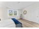 Sunlit bedroom with hardwood floors, white curtains, and a round decorative mirror at 123 E Weatherspoon St, Sanford, NC 27330