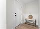 Inviting entryway featuring a white door, a stylish bench and wood grain floors at 123 E Weatherspoon St, Sanford, NC 27330