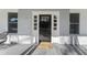 Close-up of the front door with sidelights and a welcome mat on a covered porch at 123 E Weatherspoon St, Sanford, NC 27330
