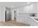 Kitchen with stainless steel appliances, white cabinetry, and wood grain flooring at 123 E Weatherspoon St, Sanford, NC 27330
