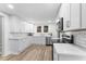 Bright kitchen with white cabinets, stainless steel appliances and wood grain flooring at 123 E Weatherspoon St, Sanford, NC 27330