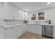 Bright kitchen featuring white cabinets, subway tile backsplash, and stainless steel dishwasher at 123 E Weatherspoon St, Sanford, NC 27330