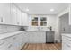 Updated kitchen with white cabinets, stainless steel dishwasher, and tile backsplash at 123 E Weatherspoon St, Sanford, NC 27330