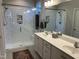 Modern bathroom featuring a double vanity and a glass-enclosed shower with white subway tile and built-in shelves at 12409 Angel Vale Pl, Durham, NC 27703