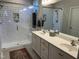 Modern bathroom featuring a double vanity and a glass-enclosed shower with white subway tile and built-in shelves at 12409 Angel Vale Pl, Durham, NC 27703