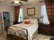 Inviting bedroom with a wrought iron bed, colorful accents, and access to ensuite bathroom at 12409 Angel Vale Pl, Durham, NC 27703