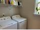 Efficient laundry room with modern washer and dryer units and convenient shelving at 12409 Angel Vale Pl, Durham, NC 27703