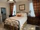 Cozy bedroom with a black metal bed frame, neutral walls and beautiful dark-wood bedside tables with accent lamps at 12409 Angel Vale Pl, Durham, NC 27703