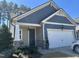 Charming home with blue shingle siding, white garage door, stone accents, and well-maintained landscaping at 12409 Angel Vale Pl, Durham, NC 27703