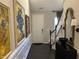 Elegant hallway features dark hardwood floors, stylish wall art, and a staircase leading to the upper level at 12409 Angel Vale Pl, Durham, NC 27703