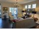 Bright living room with dark hardwood floors, neutral walls and a sliding glass door to the outside at 12409 Angel Vale Pl, Durham, NC 27703