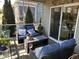 Cozy screened-in patio with comfortable blue furniture and beautiful outdoor views at 12409 Angel Vale Pl, Durham, NC 27703