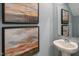 Powder room featuring framed artwork and a modern pedestal sink with chrome faucet at 158 Holton St, Smithfield, NC 27577