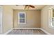 Bedroom featuring a ceiling fan and wood-look flooring, complemented by a large window at 1721 Raleigh Rd, Henderson, NC 27536