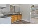 Kitchen featuring gray cabinets, oak base cabinets, stone backsplash and laminate floors at 1721 Raleigh Rd, Henderson, NC 27536