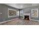 Bright living room with painted fireplace, hardwood floors, and three large windows at 1721 Raleigh Rd, Henderson, NC 27536