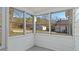 Enclosed sunroom with multiple windows providing ample natural light and neighborhood views at 1721 Raleigh Rd, Henderson, NC 27536