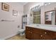 Well-lit bathroom with marble vanity top, wood cabinets, tile floors and a shower at 1796 Steel Bridge Rd, Sanford, NC 27330