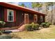 A charming entryway shows the painted siding, red metal roof and steps to the entry door at 1796 Steel Bridge Rd, Sanford, NC 27330