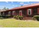A cozy porch welcomes you to this single-story home with its painted siding and red metal roof at 1796 Steel Bridge Rd, Sanford, NC 27330