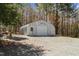 Metal outbuilding on a gravel lot with a garage door and a side door at 1796 Steel Bridge Rd, Sanford, NC 27330