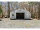 Outbuilding with a garage door and a side door on a gravel parking area at 1796 Steel Bridge Rd, Sanford, NC 27330