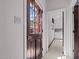 Hallway leading to laundry room, featuring a light-filled doorway and a glimpse of white appliances at 1796 Steel Bridge Rd, Sanford, NC 27330