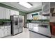 Functional kitchen with stainless steel refrigerator, white cabinets, and a window view at 1796 Steel Bridge Rd, Sanford, NC 27330